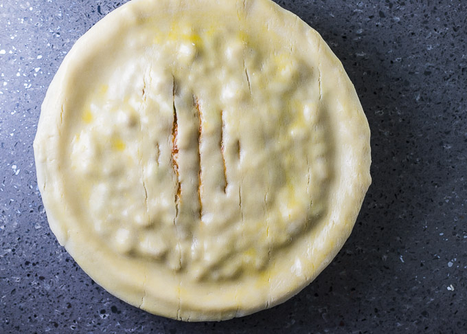 pie with slits in the top and egg wash brushed on