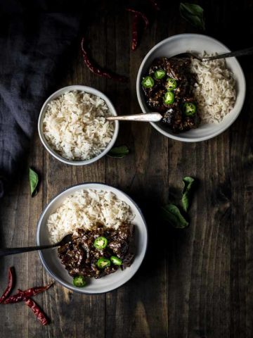 two bowls of beef and rice with chilies on top and side of rice in a bowl