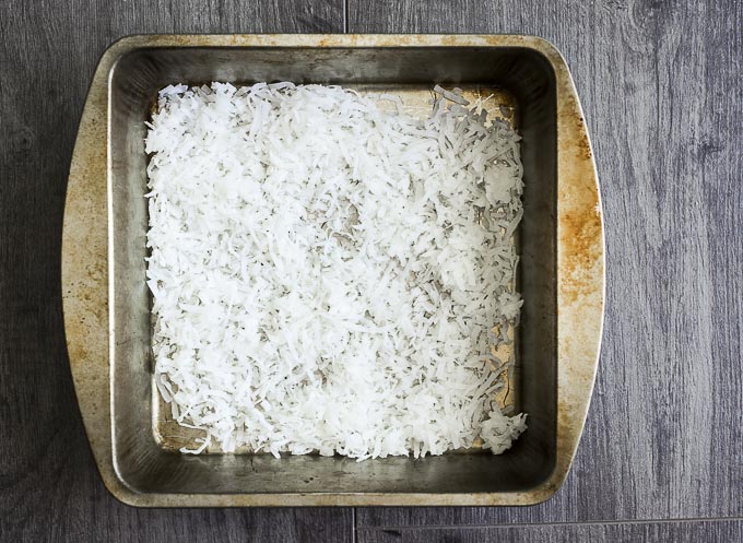 grated coconut in a metal baking dish