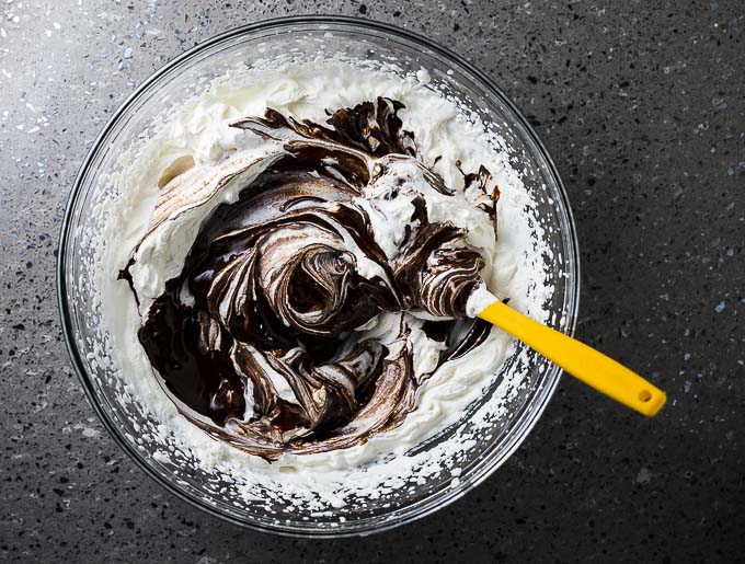 chocolate and whipped cream being mixed together in a bowl