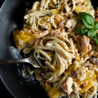 pasta with salmon and orange pieces with twirl of pasta on a fork