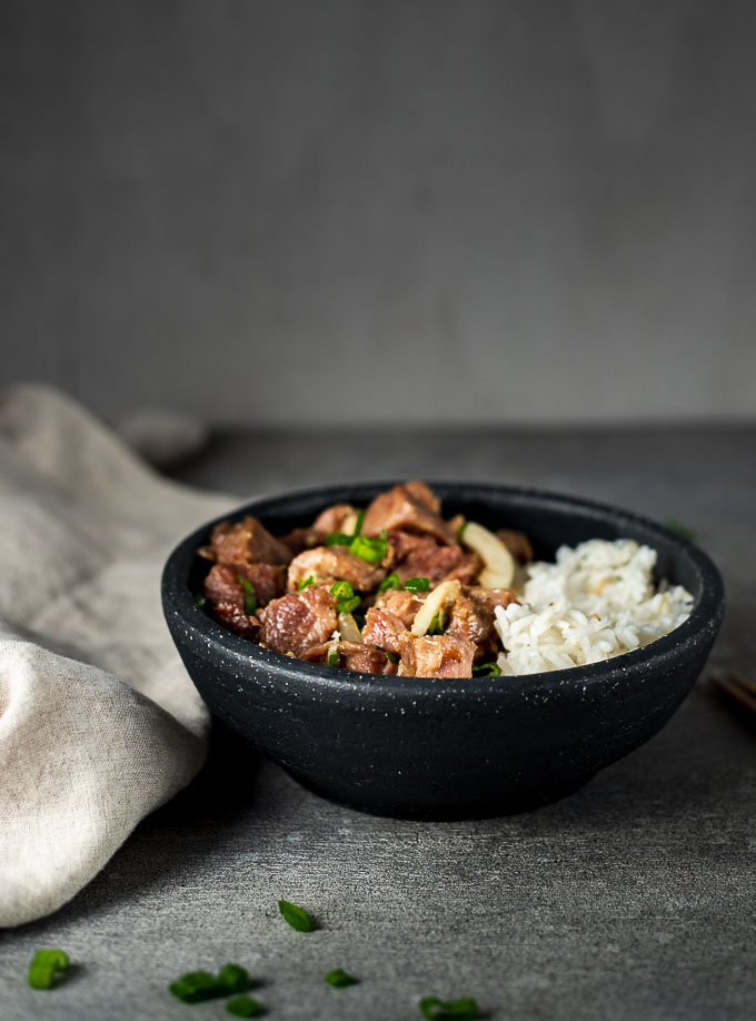 a bowl of vietnamese pork and rice with green onions