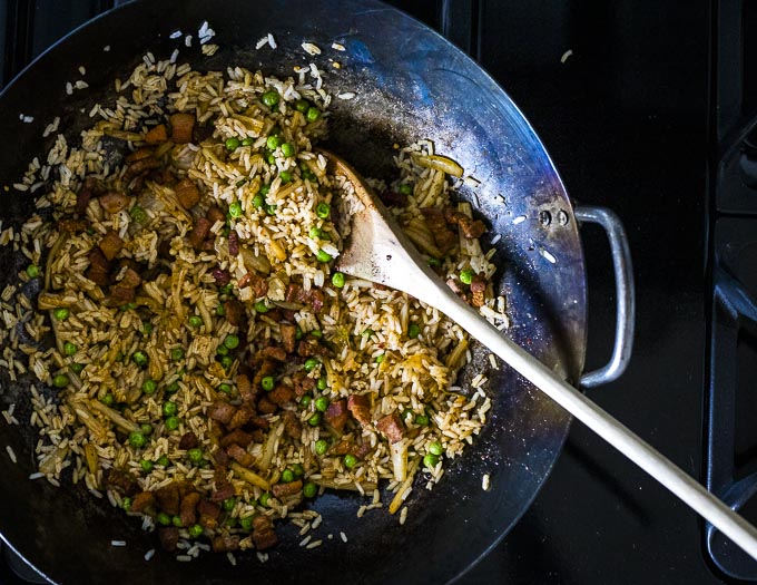 fried rice in a wok with a wooden spoon