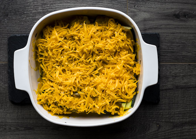 squash covered in cheddar cheese in a baking dish