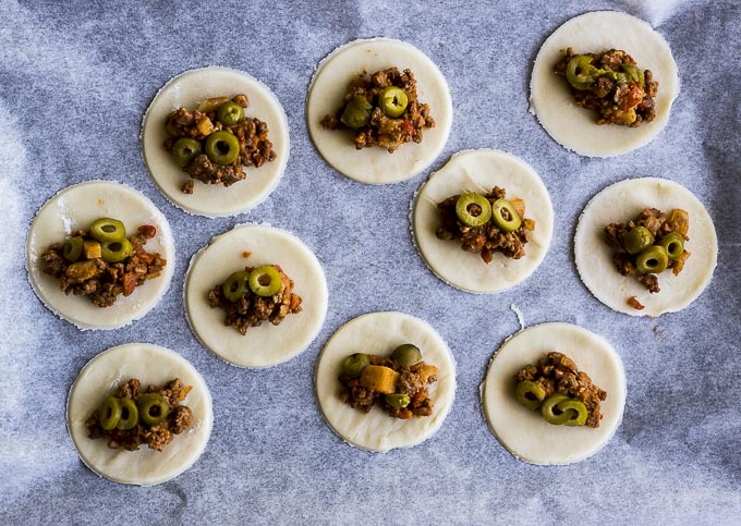 ground beef filling with olives on dough circles