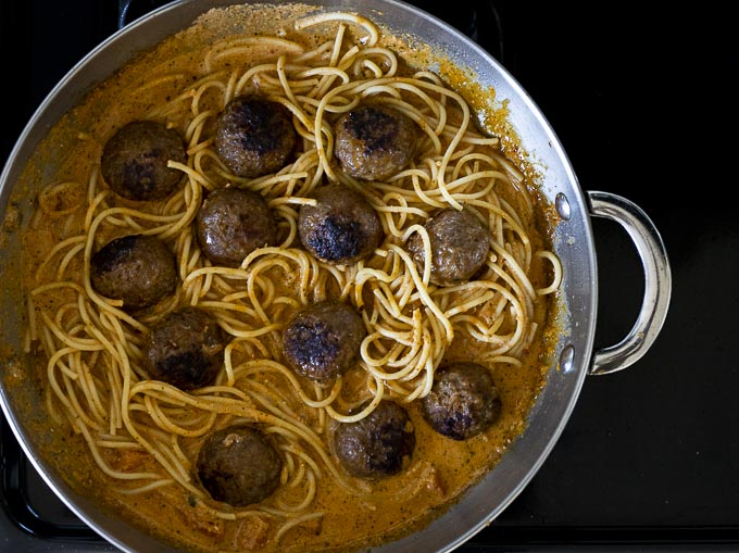 pasta and meatballs with sauce in a skillet