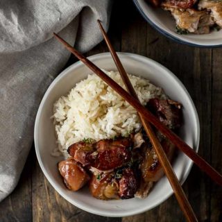 bowl of rice and pork belly with chopsticks