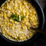 creamed corn in a bowl garnished with green onions
