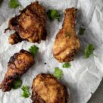 fried chicken on pasrchment paper garnished with cilantro