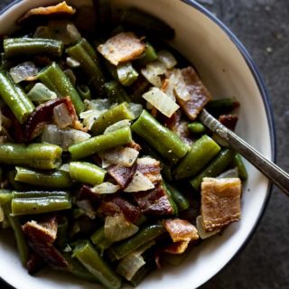 green beans mixed with bacon and onions in a bowl