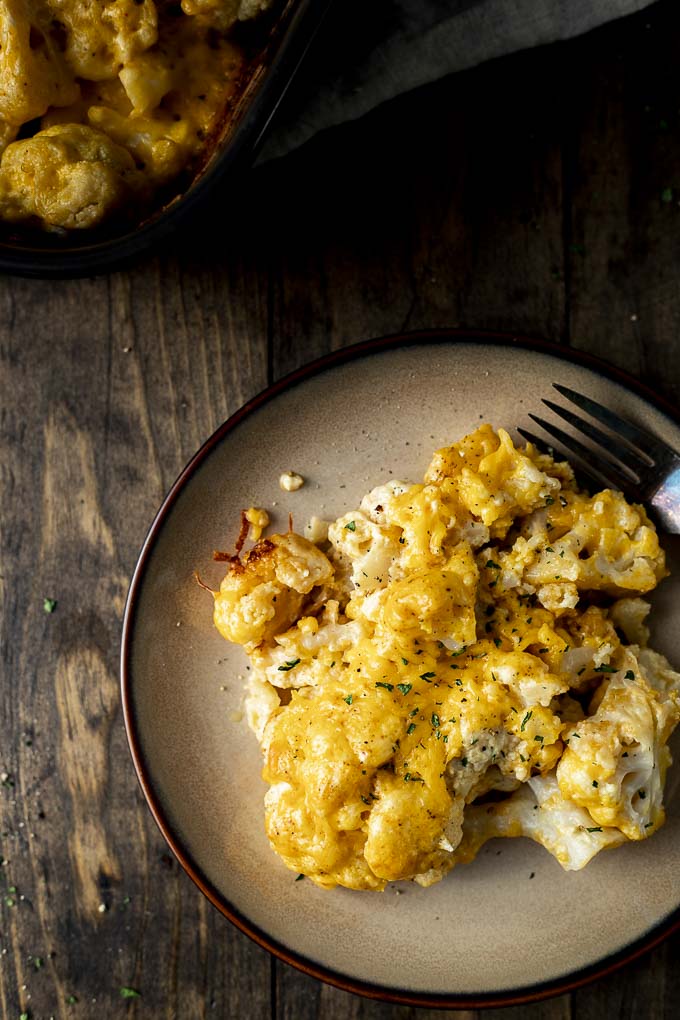 cauliflower baked in cheese on a plate with a fork