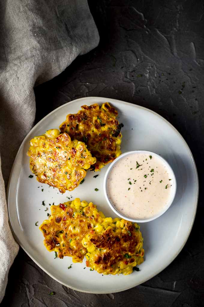 corn fritters on a plate with dipping sauce