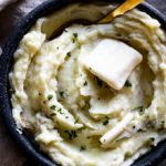 bowl of mashed potatoes with butter and a spoon