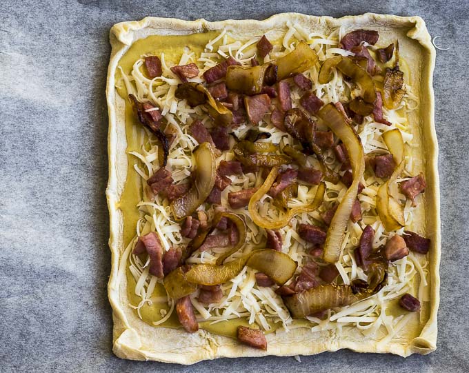 ham, onions and cheese on raw puff pastry dough