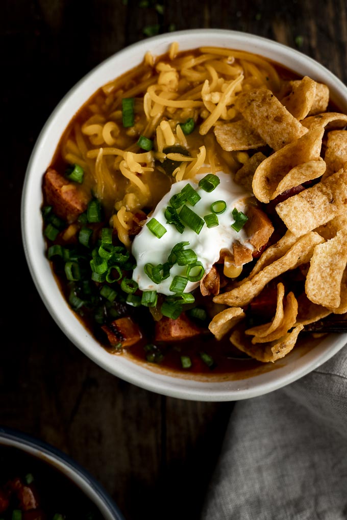 bowl of chili with cheese, sour cream and fritos