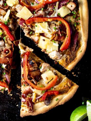 slice of pizza with red peppers, chicken and pineapple