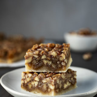 2 pecan pie bars stacked on a plate