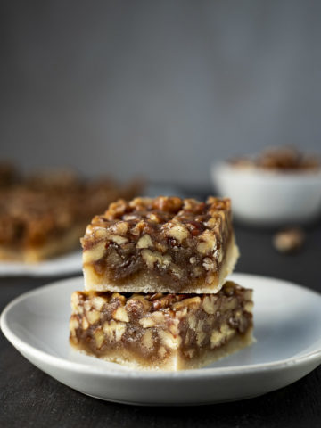 2 pecan pie bars stacked on a plate