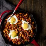 skillet of sweet potato hash with eggs on top
