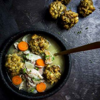 bowl of soup with carrots and stuffing dumplings