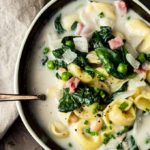 bowl of tortellini soup with spinach and peas