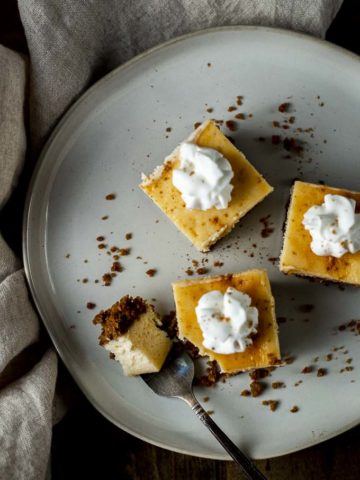 3 eggnog cheesecake bars on a plate with a fork