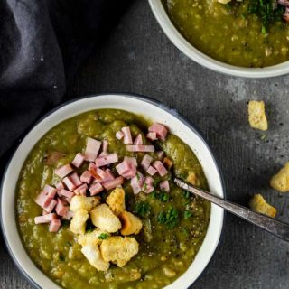 2 bowls of split pea soup with ham and croutons