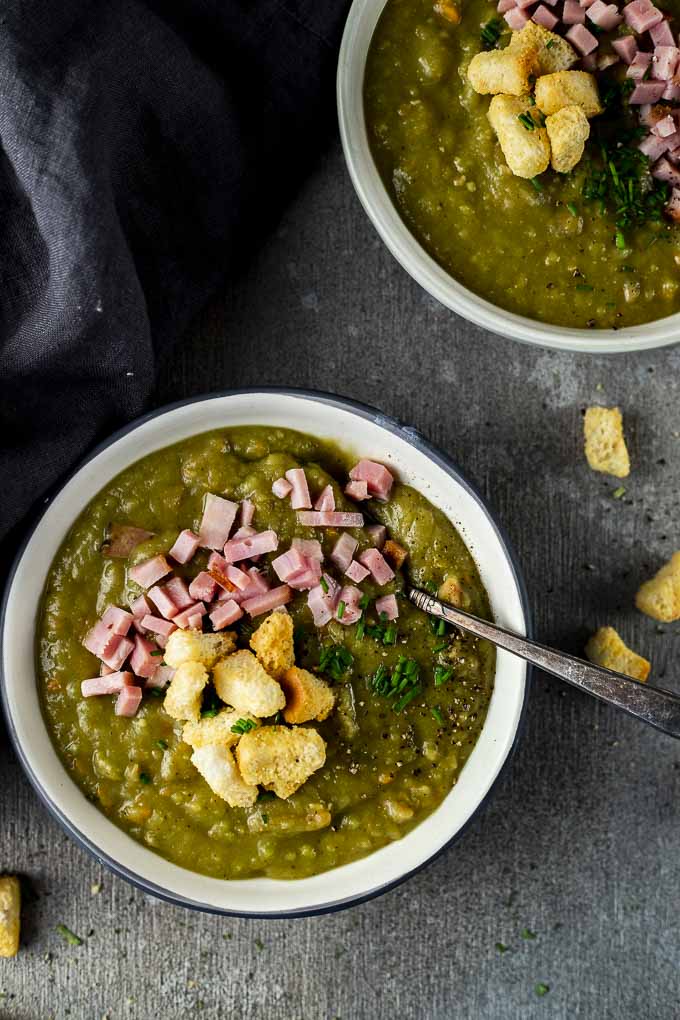 2 bowls of split pea soup with ham and croutons