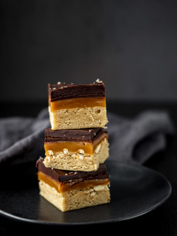 millionaire shortbread bars in a stack (shortbread, caramel, chocolate layers)