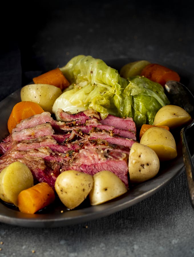 a plate of corned beef with vegetables