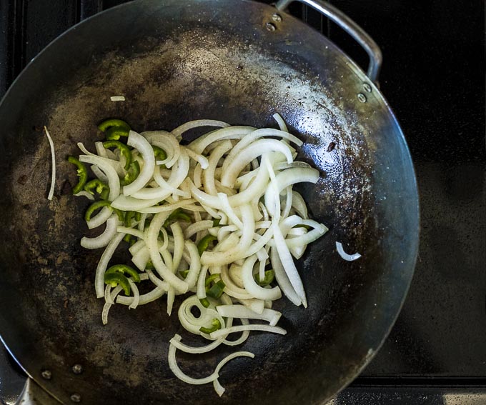 onions and jalapenos in a wok