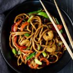 shrimp lo mein in a bowl with chopsticks