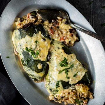 2 baked poblano peppers on a plate with stuffing