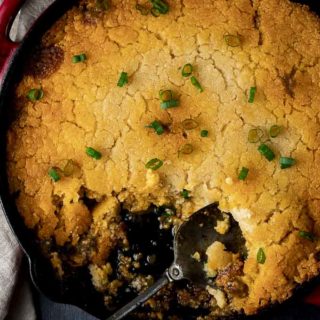skillet of tamale pie with a spoon