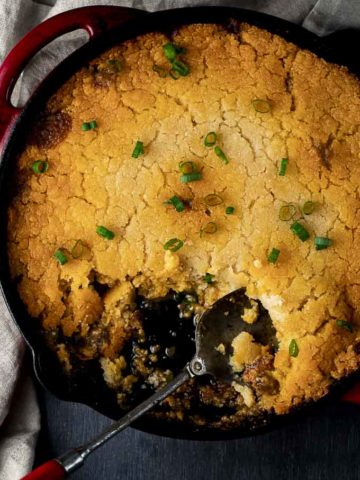 skillet of tamale pie with a spoon