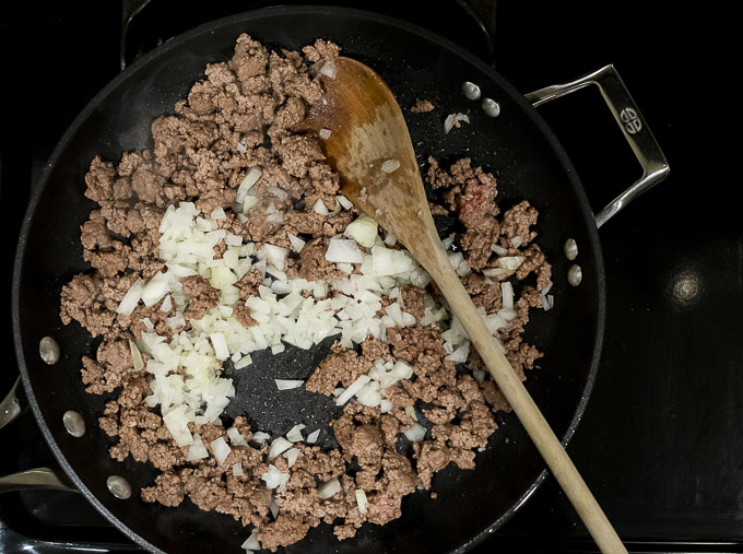 ground beef with onions in a skillet
