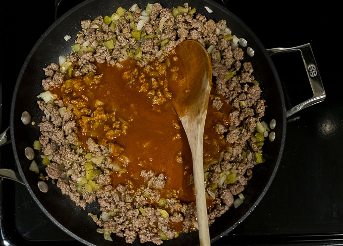 ground beef in a skillet with red sauce