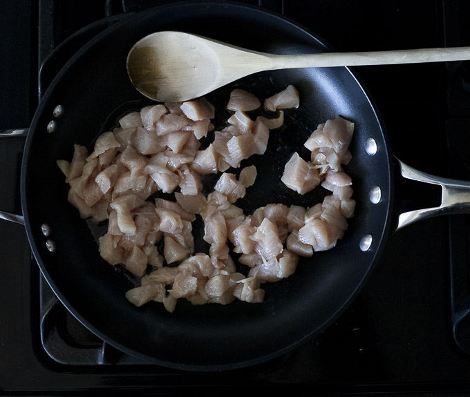 chicken pieces being sauteed in a skillet