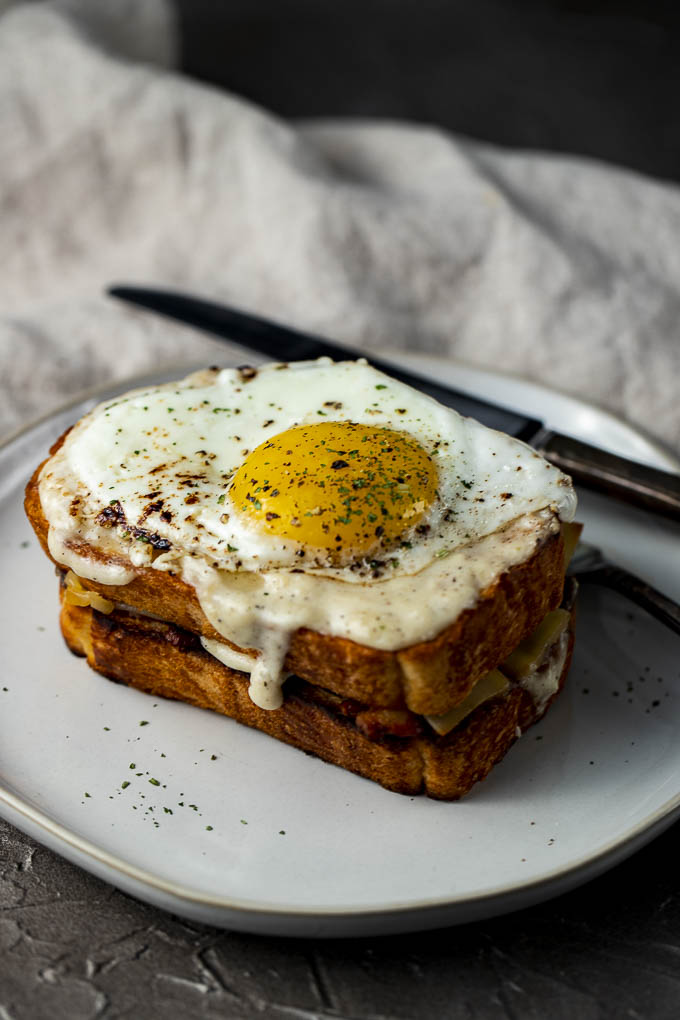 egg topped sandwich with sauce