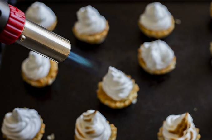 kitchen torch being used on meringue tarts
