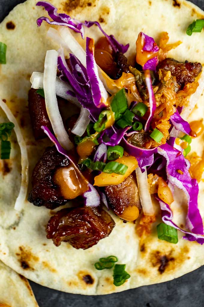 pork taco with cabbage, green onions and orange sauce