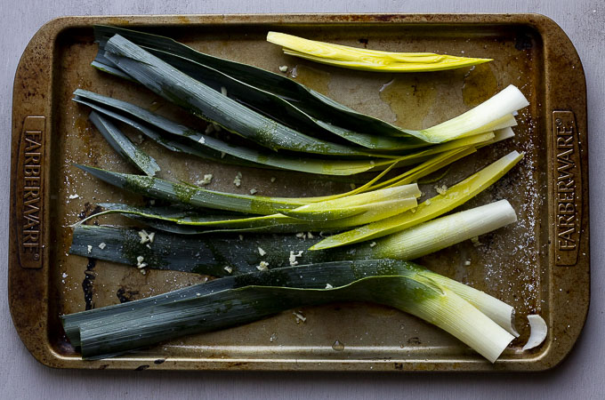 raw leeks on a tray with oil and seasoning