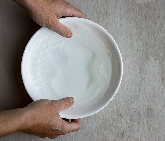 rice paper being soaked in a bowl of water
