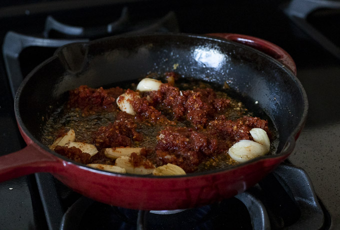 red sauce and garlic cloves in a skillet