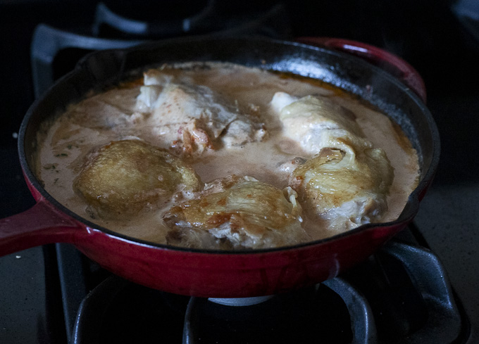 chicken in a skillet with creamy sauce