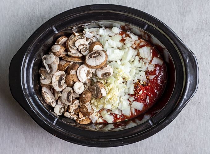mushrooms, onions, tomatoes and seasonings in a crockpot