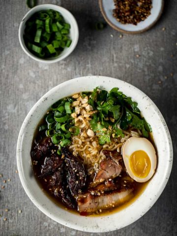 bowls of ramen with pork, noodles, egg and vegetables