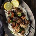 chicken kabobs on a plate with rice