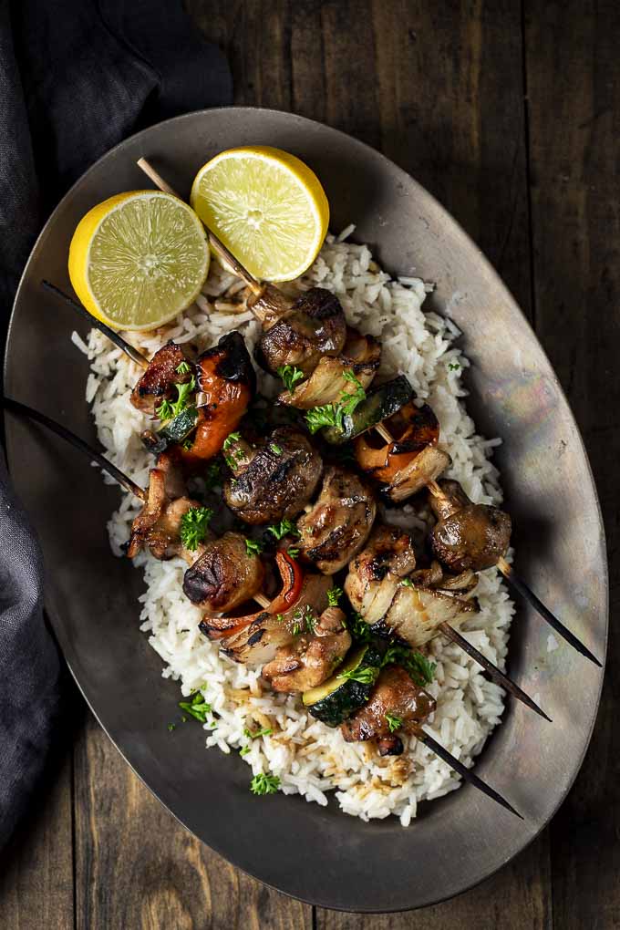 chicken kabobs on a plate with rice