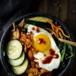 bowl of vegetables, shrimp and kimchi with a spoon
